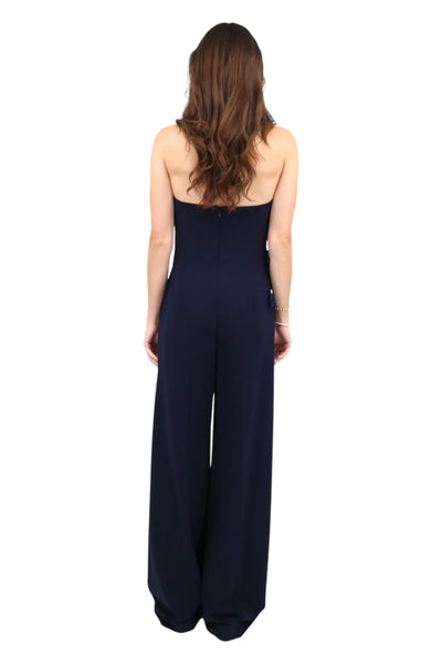 Woman wearing a navy blue strapless jumpsuit on a white background