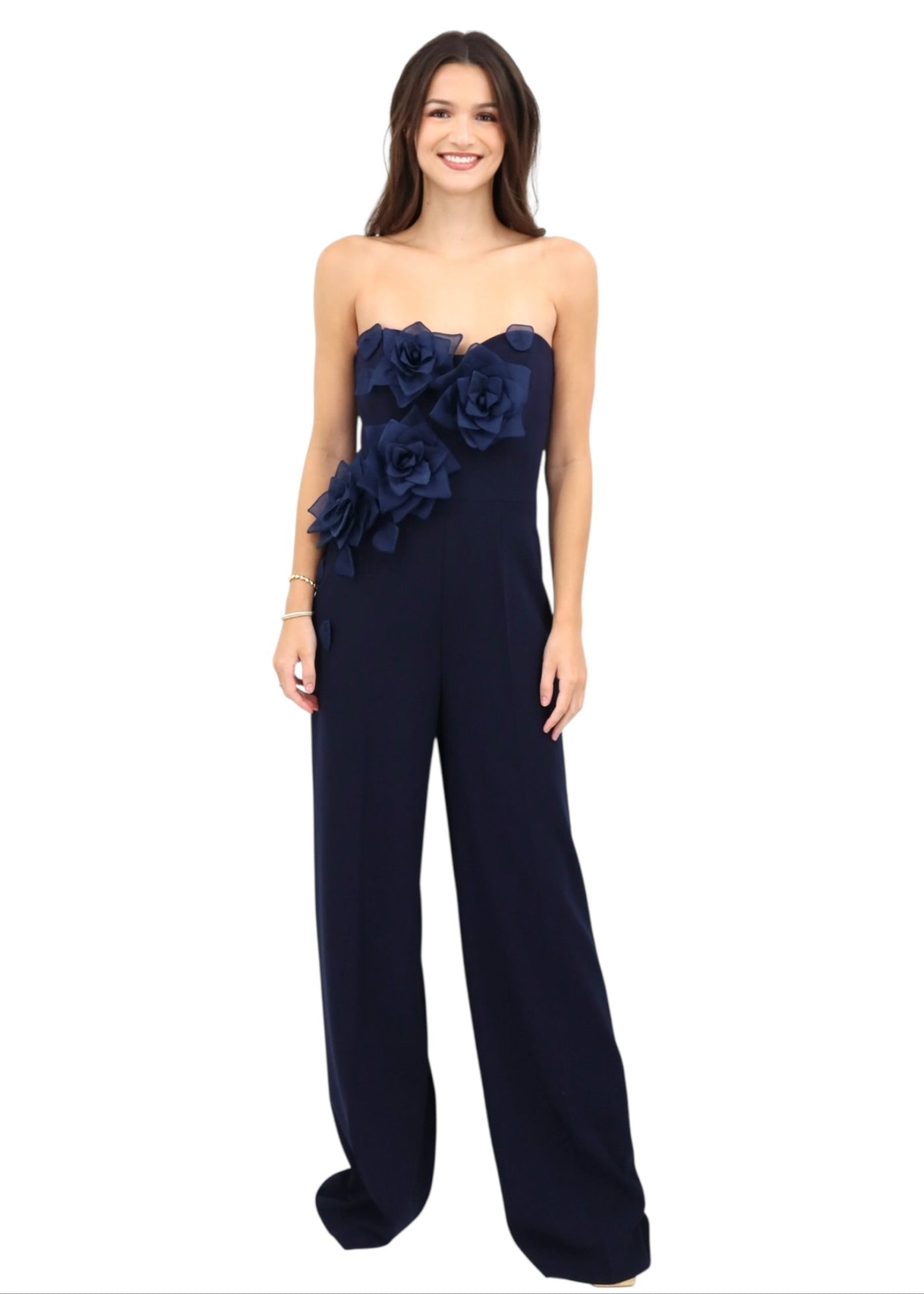 Navy strapless jumpsuit with floral embellishments on a white background